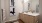 Photo of Bathroom that is featuring the double vanity, mirror, modern light fixture and wooden cabinets