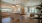 Kitchen featuring an island and counters that surround the outside of the kitchen, with light pendants and a view into the expansive living room.