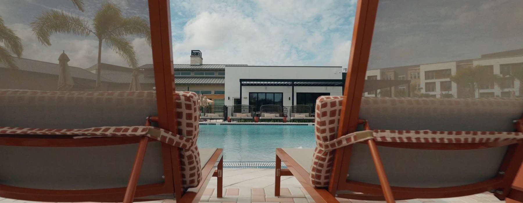 Two lounge chairs by a pool